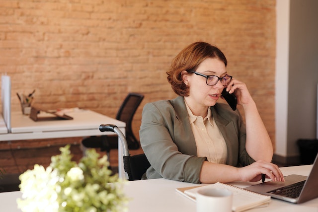 person in suit talking on the phone in an office